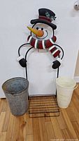Overview of snowman stand, galvanized bucket, cream flower bucket