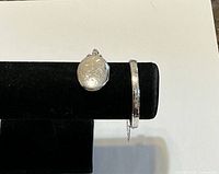 Locket and bracelet displayed on black velvet bar