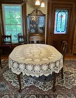 Table view showing full oval crocheted tablecloth on dining table