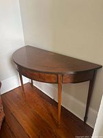 Front and side view of demilune console table showing overall form and leg style