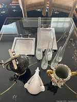 All items grouped on glass table: trays, vases, globe, pitcher, polar bear