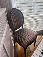 Front side view of oval-back chair positioned near window and radiator cover
