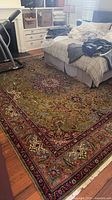 Full view of Persian Tabriz rug under bed and exercise equipment