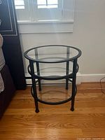 Full view of round 3-tier table beside bed