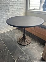 Full view round metal table and cast iron base