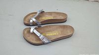 Top view of both sandals showing straps, footbed branding and wear