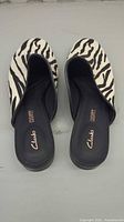 Top view of both zebra print Clarks mules
