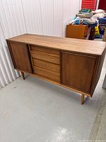 Full front view of walnut credenza showing drawers and sliding doors