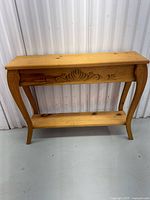 Front view of pine console table showing carved apron and overall form