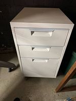 front view of white three-drawer cabinet on casters