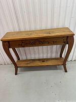 Full front view of pine console table showing carved apron, legs, shelf