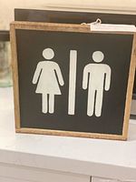 Front view of square restroom sign