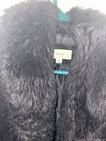 Close-up of black faux-fur collar and interior tag