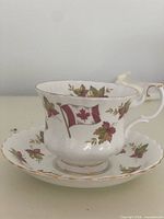 Cup and saucer showing maple leaf and flag decoration