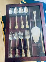 Flatware set in box showing six spoons, six forks and cake server