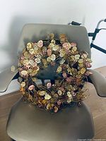 Mixed metallic metal leaf wreath displayed on chair