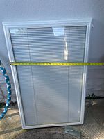 Front view of framed glass insert with blinds showing width measurement