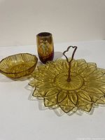 Overview of all three items: amber tray with handle, amber bowl, red vase with frog