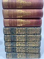 Stacked view of all eight books showing spine designs and titles