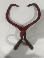 Full view of red forged ice tongs showing overall shape