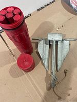 Anchor alongside red flare container with lid removed showing six flares