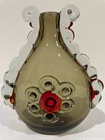 Front view of smoky grey art glass vase with clear and red applied decoration