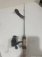 Full view Celsius ice fishing rod with reel on white surface