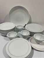 Entire group of white ceramic plates, bowls and pedestal bowls