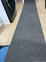 Full view of grey runner-size rug pad laid flat