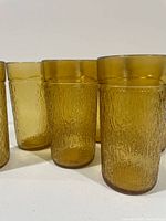 Front view of several amber Kerr tree bark tumblers