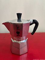 Left-side view showing logo, handle, knob, octagonal design