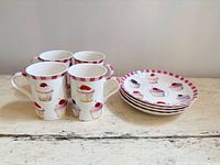 Full set: four mugs stacked and four plates stacked, showing pattern