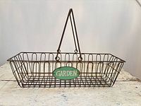 Full view of metal wire basket with swing handles and green "GARDEN" tag