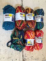 Group shot of seven skeins showing assorted colourways and labels
