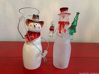 Both glass snowman figurines side by side
