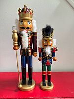 Full view of both wooden nutcracker figurines on bases