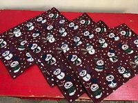 All four woven placemats on red surface, showing overall design and quantity