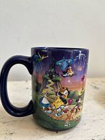 Left side of mug showing Cinderella Castle, Genie, Alice, Belle, Beast and additional character artwork