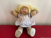 Full view of seated doll showcasing entire outfit and overall condition