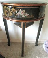 Front view of demi-lune table showing legs, apron artwork and overall form