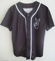 Full front view of black Pink City jersey showing white piping and peace sign graphic