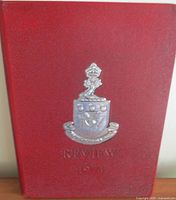 Front cover showing red boards and silver embossed crest with title Review 1974