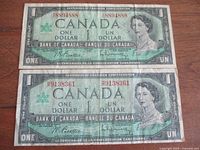 Front view of both 1967 Canadian $1 Centennial notes displaying wear