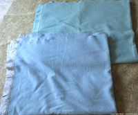 Both wool blankets folded, showing colors and satin trim