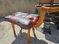 Side view showing carved camel head, seat, legs