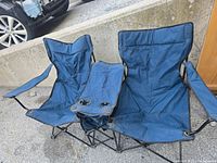 Front view of blue double camping chair fully opened showing two seats and center console with cup holders