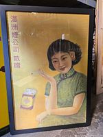 Full view of framed poster showing image of woman, cigarette pack and Chinese text