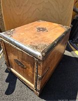 angled view of wooden box showing brass corners and sides