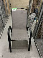 Front view of grey fabric sling patio chair with black metal frame