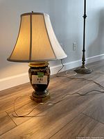 Lamp with shade lit and on floor